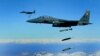 FILE - U.S. Air Force F-15E Strike Eagle aircraft from the 335th Fighter Squadron drop 2,000-pound joint direct attack munitions on a cave in eastern Afghanistan, Nov. 26, 2009.