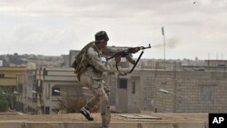 A Libyan revolutionary fighter fires his machine gun while attacking pro-Gadhafi forces on the western side of Sirte, Libya, October 13, 2011.
