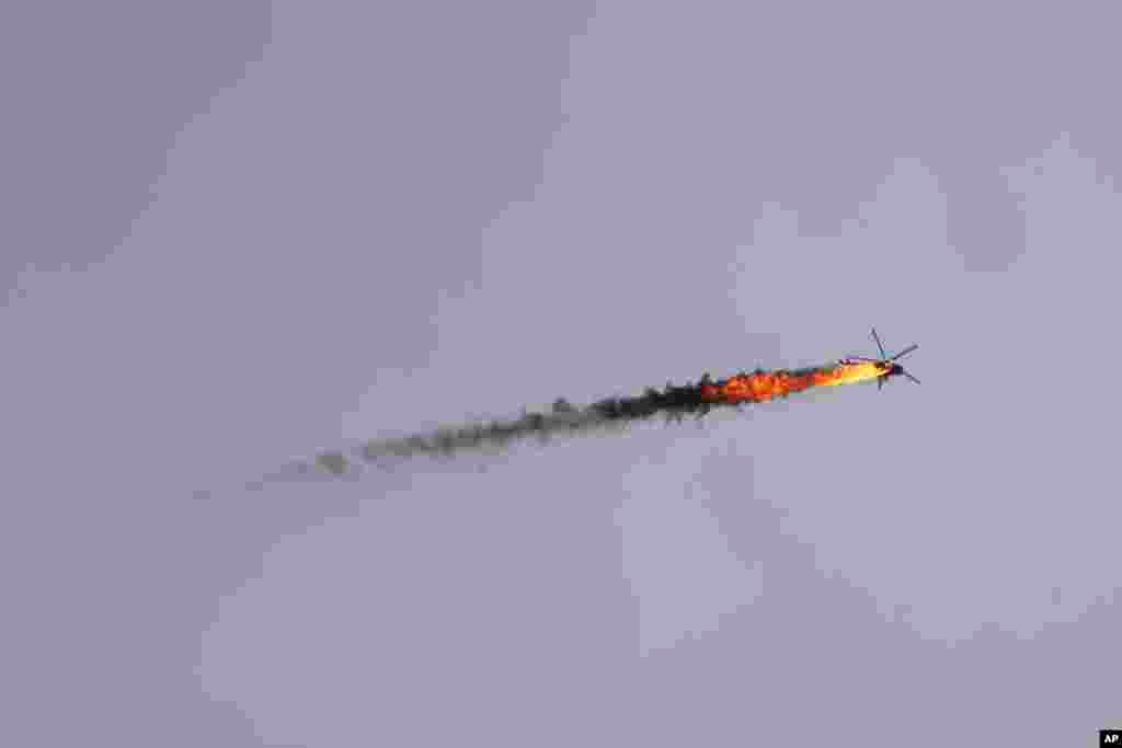 Syrian government helicopter is shot by a missile in Idlib province.