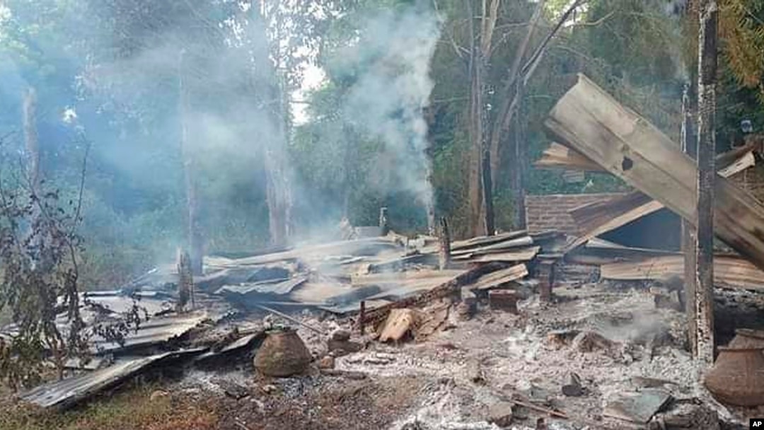 FILE - Smoke rises from debris and corrugated roofing of a school building that was burned to the ground in Taung Myint village in the Magway region of Myanmar on Oct. 16, 2022.
