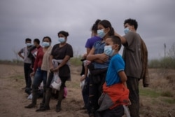 Aproximadamente una docena de menores no acompañados de América Central que buscan asilo son separados de otros migrantes por agentes de la Patrulla Fronteriza de EE. UU. tras cruzar el río Grande, el 14 de marzo de 2021.
