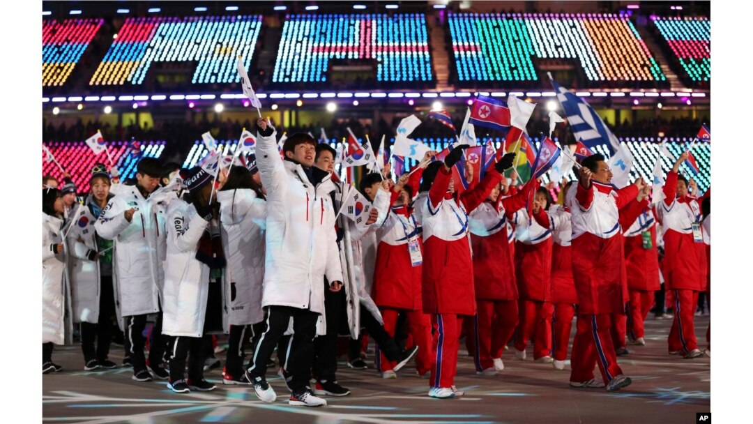 FILE - North and South Koreans wave flags during the closing ceremony of the 2018 Winter Olympics in Pyeongchang, South Korea, Feb. 25, 2018.