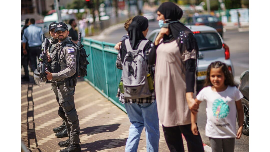 Police stand by during a demonstration calling for justice in the killing of Musa Hassuna in the mixed Arab-Jewish town of Lod, central Israel, Friday, May 28, 2021. (AP Photo/David Goldman)