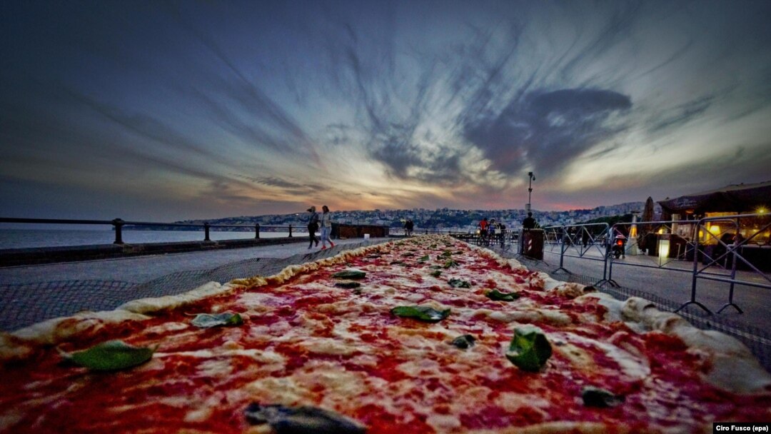 A general view of a Neapolitan pizza made to break the world record for the longest pizza ever made, by making a two kilometers margherita (16 inch wide) pizza stretching along the city waterfront, in Naples, Italy, 18 May 2016.