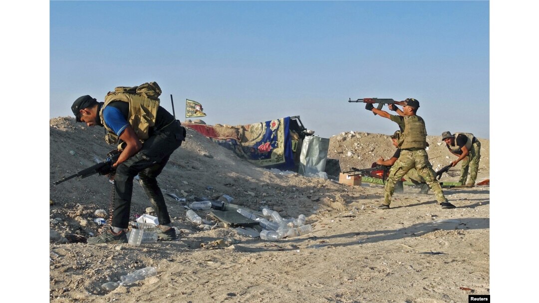 Iraqi security forces fire their weapons during clashes with Islamic State militants on the outskirts of Ramadi, June 15, 2015.