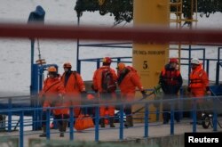 Russian Emergencies Ministry members walk on a pier near the crash site of Russian military Tu-154 plane in the Black Sea in the Sochi suburb of Khosta, Russia, Dec. 25, 2016.