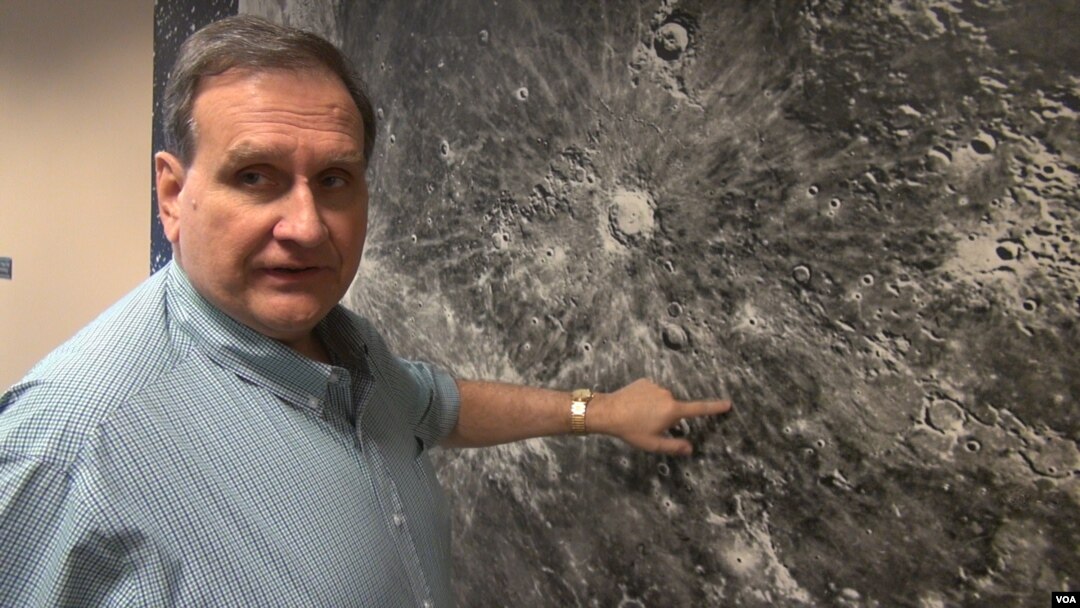 Paul Spudis with a moon mural at the Lunar and Planetary Institute in Houston, Texas. (G. Flakus/VOA)