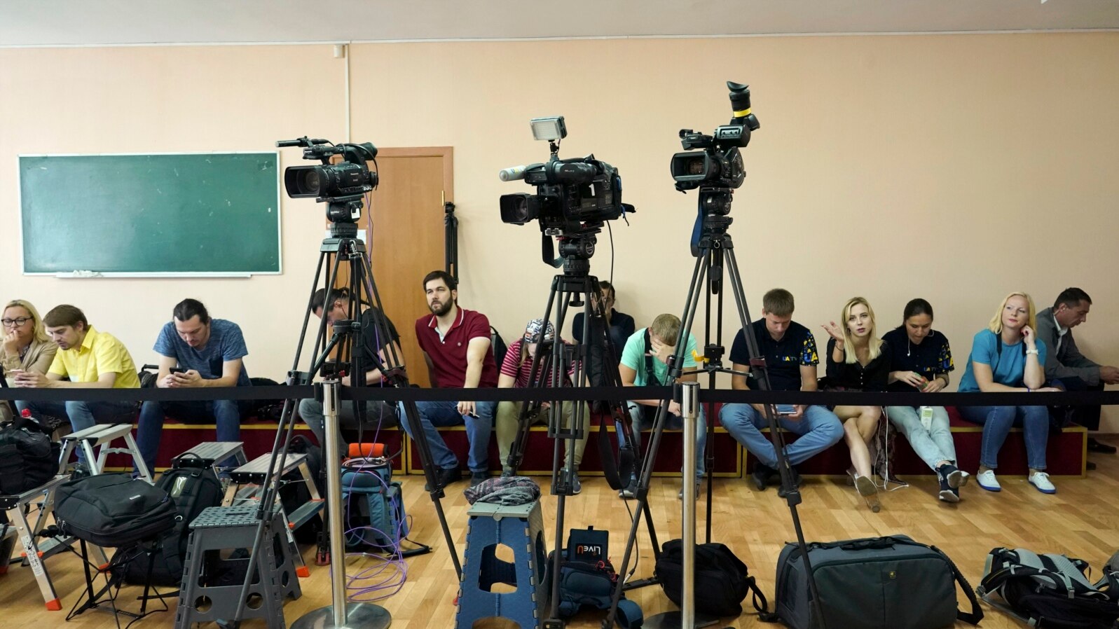 FILE - Journalists wait for President Volodymyr Zelenskiy's arrival at a polling station during parliamentary elections, in Kyiv, Ukraine, July 21, 2019. 