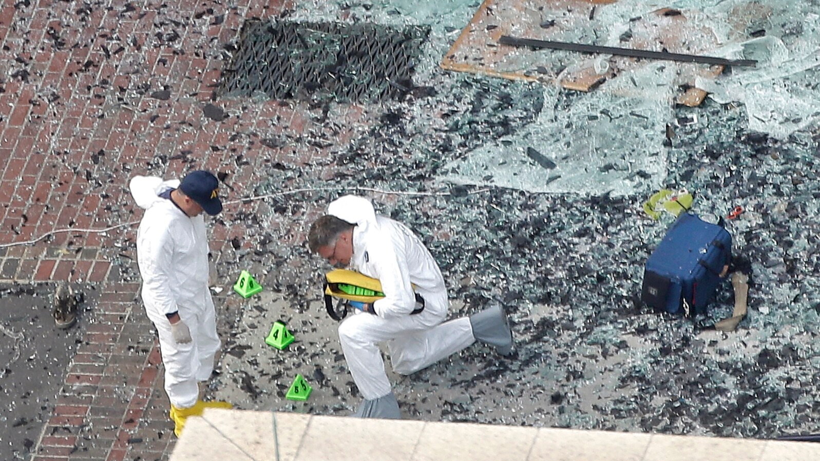 Boston Marathon ExplosionsTwo men in hazardous materials suits put numbers on the shattered glass and debris as they investigate the scene at the first bombing on Boylston Street near the finish line of the 2013 Boston Marathon, a day after two blasts kil
