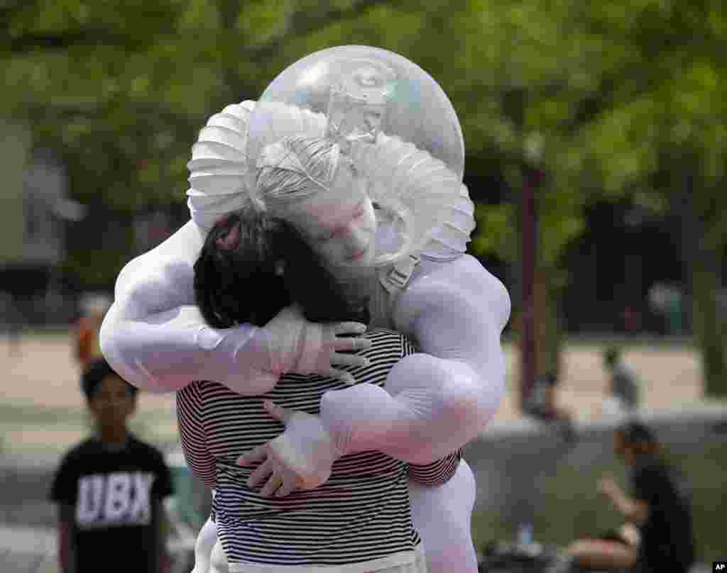 A tourist gets an "Art Hug" from a disinfected costumed man outside the reopened Rijksmuseum in Amsterdam, Netherlands.