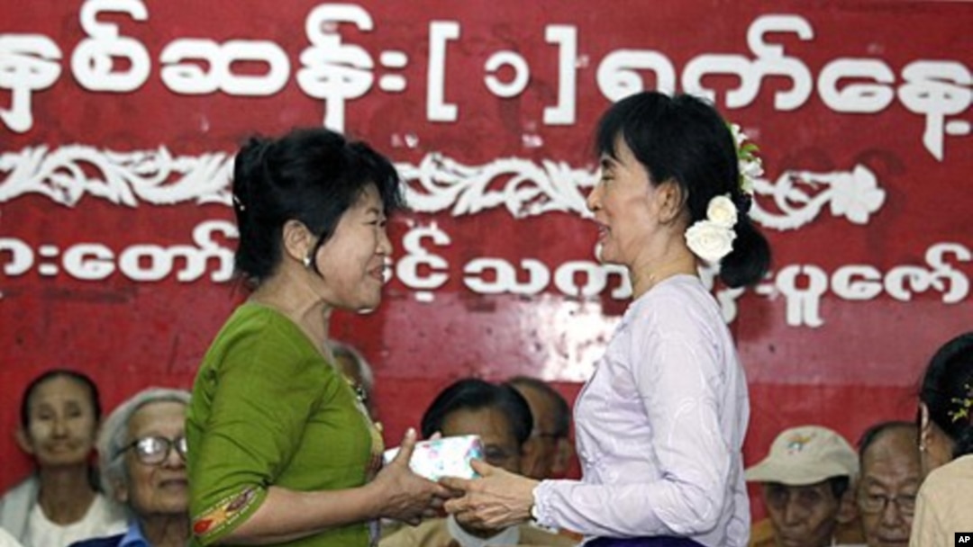 Burma's pro-democracy leader Aung San Suu Kyi (R) presents an Unknown Hero Award to a relative of Than Naing Oo, who is currently in prison, at National league for Democracy (NLD) head office in Yangon, April 17, 2011