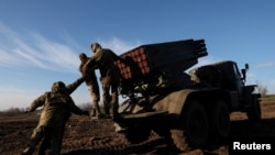 Ukranian service members prerpare to lauch rockets in the Bakhmut region