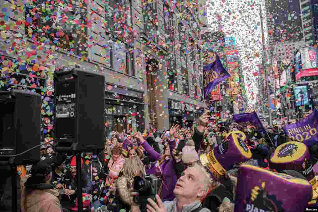 People watch confetti throwing from the Hard Rock Cafe marquee during an annual confetti test ahead of the New Year's Eve ball-drop celebrations in Times Square in New York City, Dec. 29, 2019.