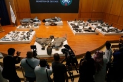Journalists film what Saudi military spokesman Col. Turki al-Maliki said was evidence of Iranian weaponry used in the attack on Saudi Aramco's facilities in Abqaiq and Khurais, during a press conference in Riyadh, Saudi Arabia, Sept. 18, 2019.