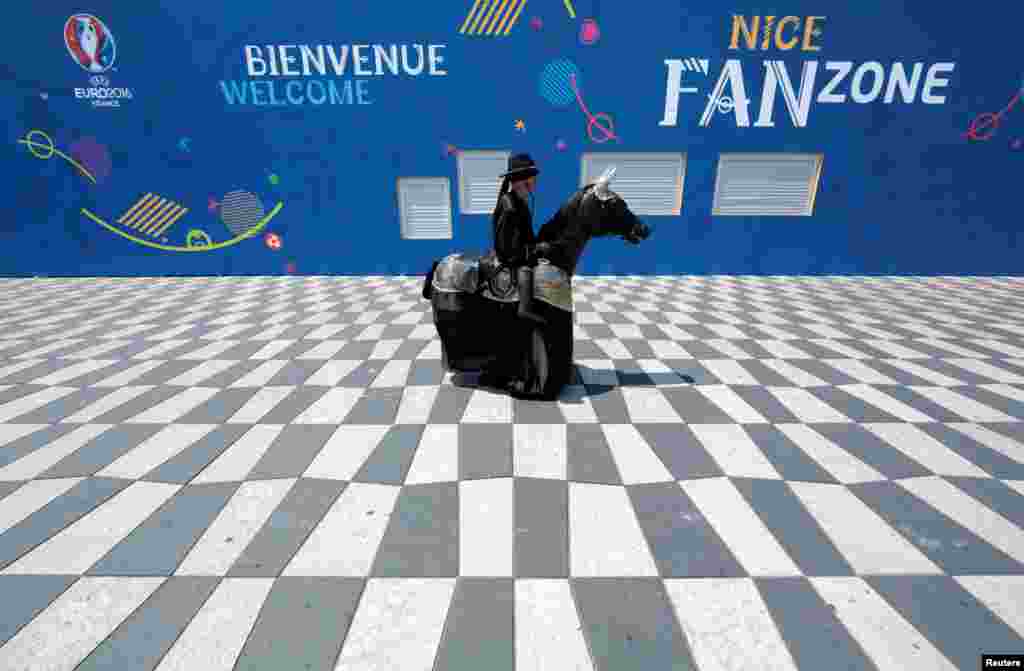 Seorang seniman jalanan mengenakan kostum 'Zorro' menjelang pembukaan kejuaraan sepakbola Eropa 2016 di Nice, Perancis.