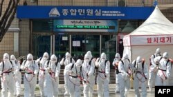 Soldados surcoreanos usan desinfectante protector en aerosol como parte de las medidas preventivas contra la propagación del coronavirus COVID-19, en el ayuntamiento de Daegu el 2 de marzo de 2020.