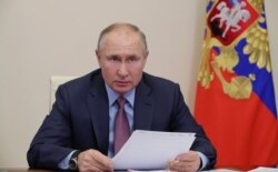 FILE - Russian President Vladimir Putin chairs a video-conference meeting at Novo-Ogaryovo state residence outside Moscow, Russia, Feb. 10, 2021.