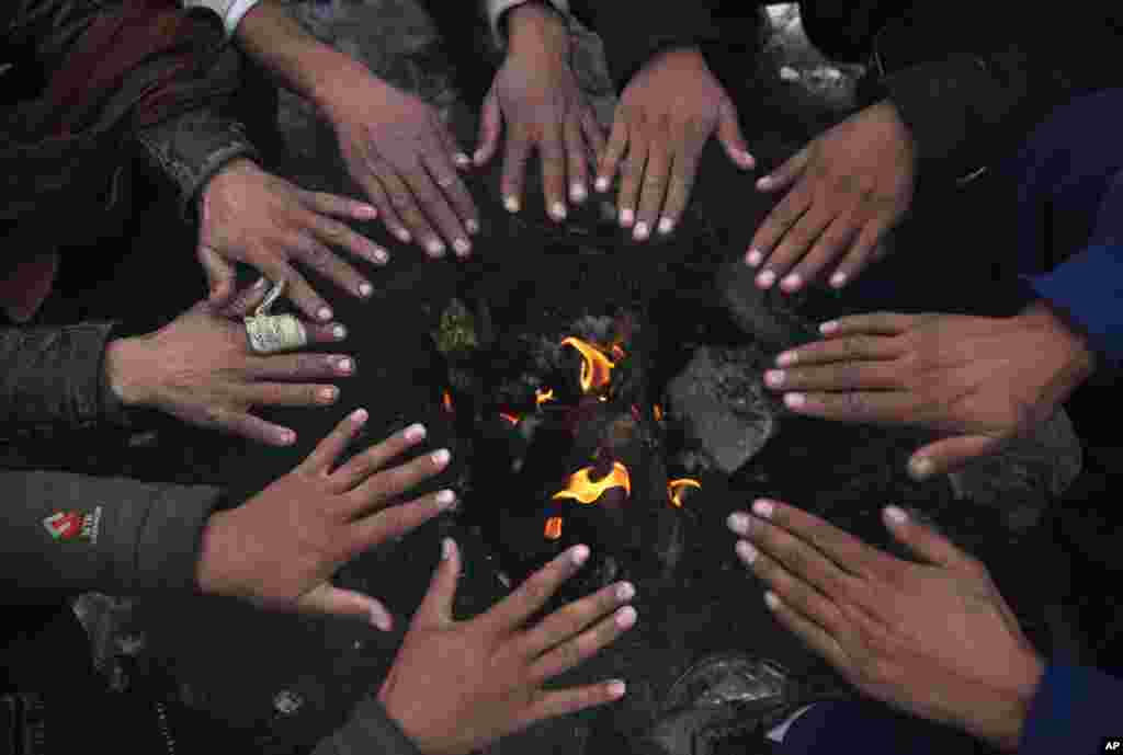 People sit around a fire to warm themselves after a heavy snowfall in Kabul, Afghanistan.