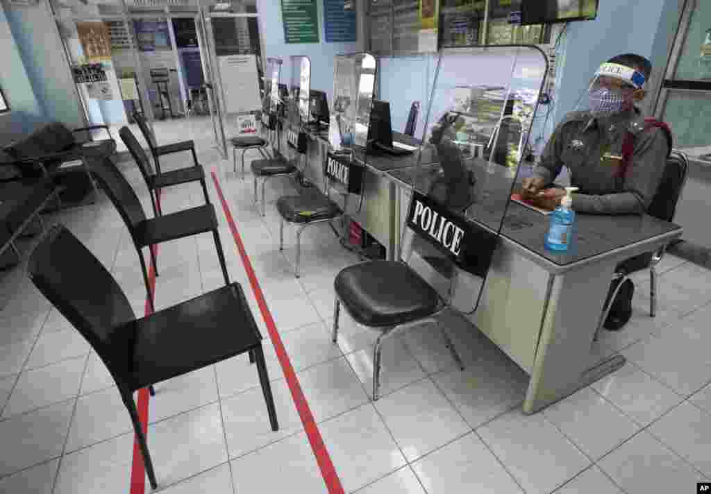 Police use riot shields to practice social distancing to help curb the spread of the coronavirus at the Tha Phra police station in Bangkok, Thailand.