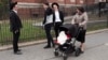 A woman, right, who identified herself as Ester, passes a group of boys, April 9, 2019, in the Williamsburg section of Brooklyn, New York. Ester says that she does not believe that the measles vaccination is safe.