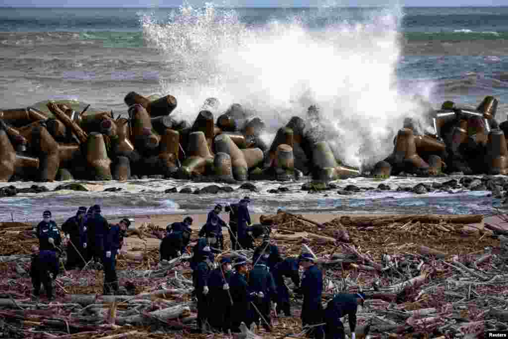 Police officers take part in a search operation for the remains of people who went missing after the March 11, 2011 earthquake and tsunami disaster in Namie, Fukushima prefecture, Japan.