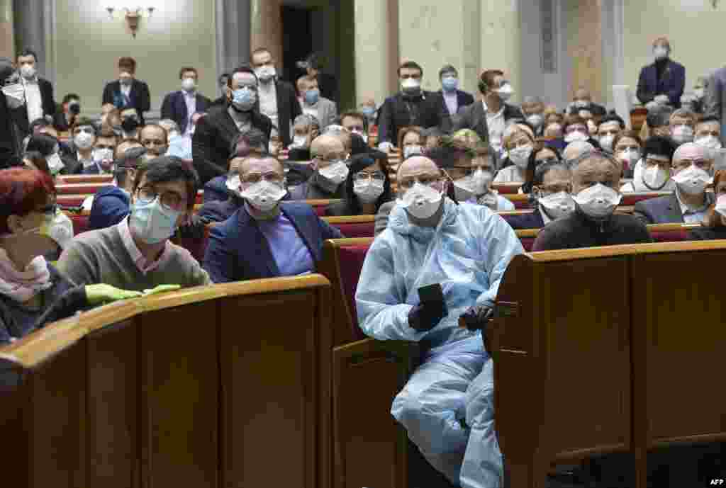 Ukrainian lawmakers wearing face masks to protect against coronavirus attend an extraordinary parliamentary session in Kyiv.