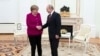 Russian President Vladimir Putin, right, and German Chancellor Angela Merkel Greer each other prior to the talks in the Kremlin in Moscow, Russia, Jan. 11, 2020.