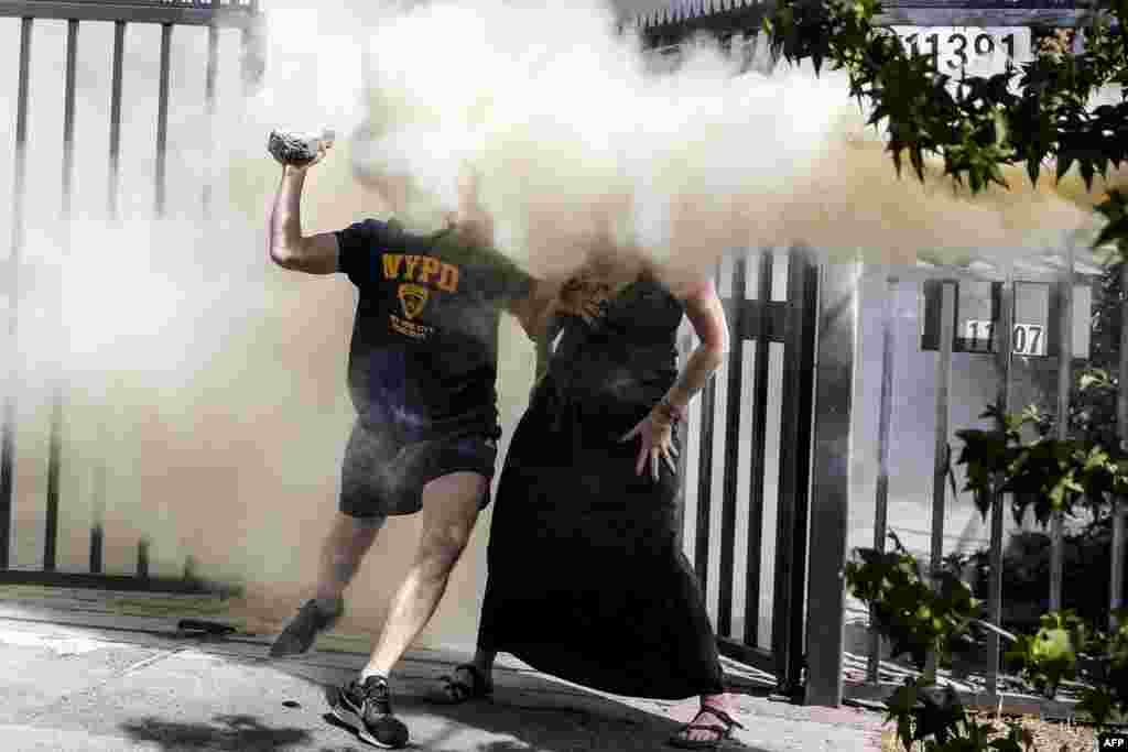 Neighbors of the Chilean President Sebastian Pinera are sprayed with a fire extinguisher by protesters near Pinera's house in Santiago, Dec. 1, 2019.