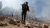 Houthi rebel fighters inspect the damage after a reported airstrike carried out by the Saudi-led coalition targeted the presidential palace in the Yemeni capital Sana'a, Dec. 5, 2017.