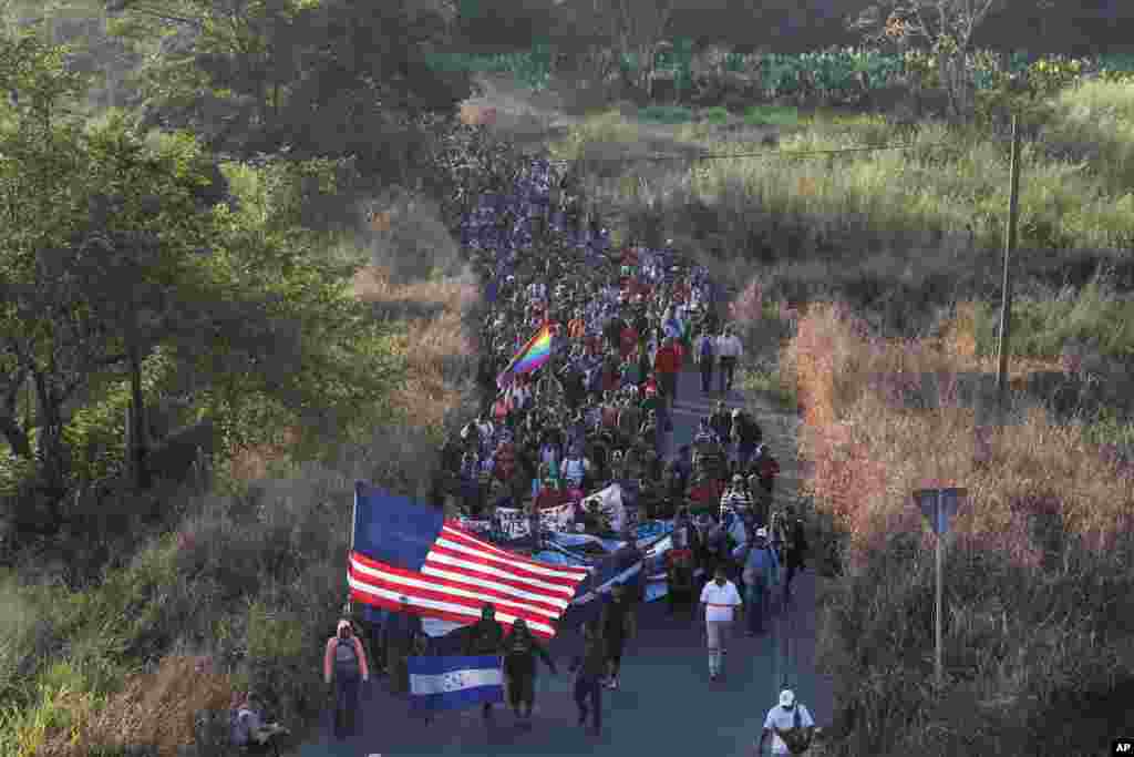 Central American migrants walk carrying a handmade U.S. flag and banners, after crossing the Suchiate River from Guatemala in Ciudad Hidalgo, Mexico.