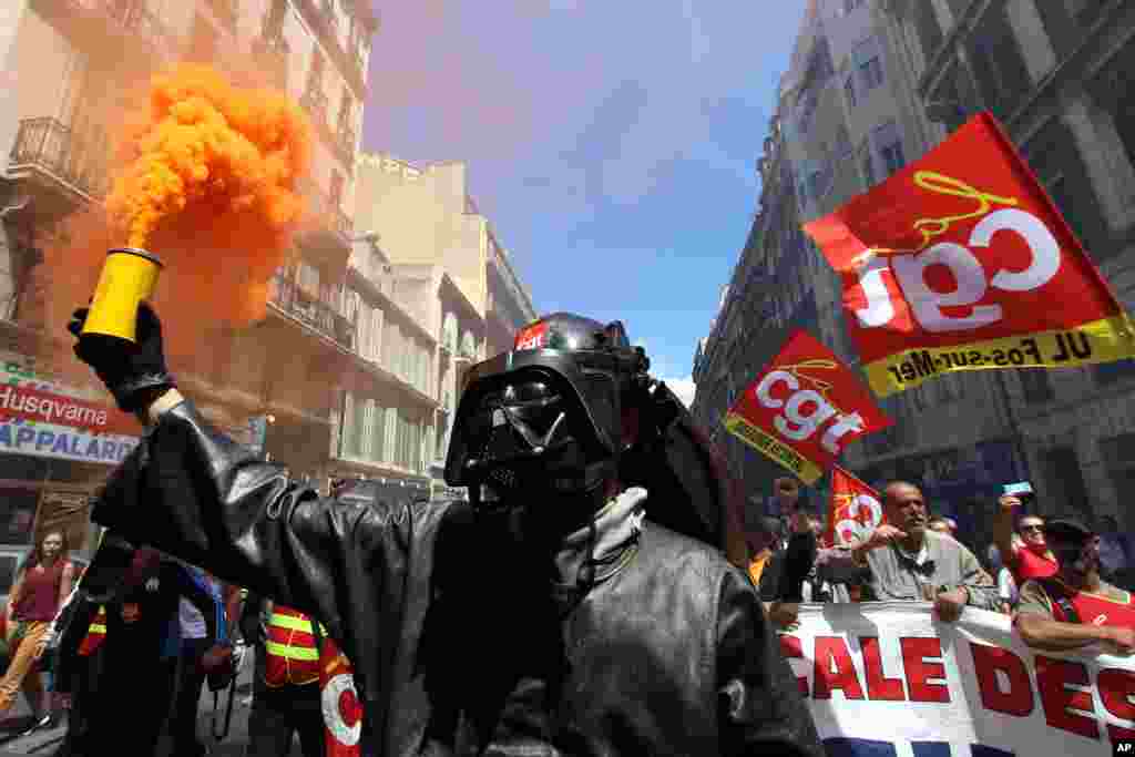 Seorang pekerja pabrik baja di Fos-sur-Mer mengenakan topeng 'Darth Vader', pada aksi demonstrasi buruh di Marseille, Perancis selatan.