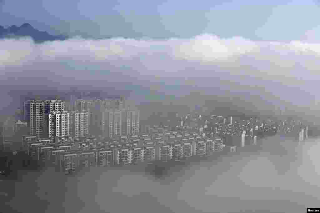 Gedung-gedung permukiman terlihat seperti dikelilingi awan pasca hujan di Huangshan, Anhui, China.