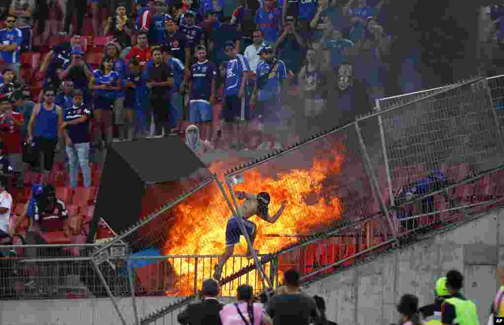 A small group of anti-government protesters set a section of the stadium on fire during the Copa Libertadores soccer game between Universidad de Chile and Brazil's SC Internacional, in Santiago, Chile, Feb. 4, 2020.