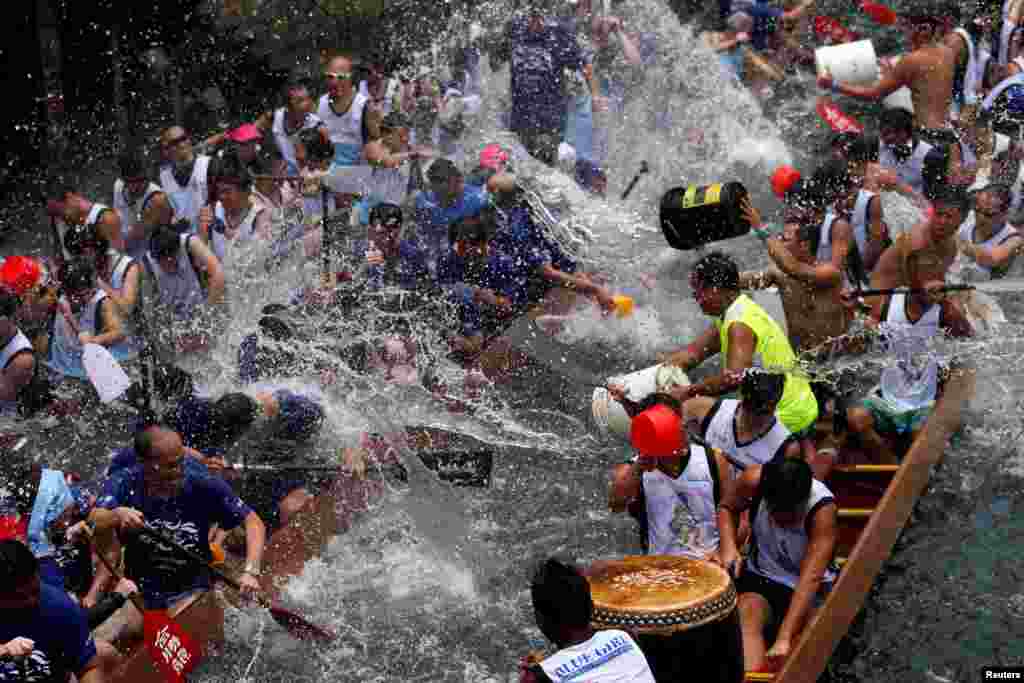 Participants splash water during a ceremony during Tung Ng or Dragon Boat Festival at Aberdeen fishing port in Hong Kong.