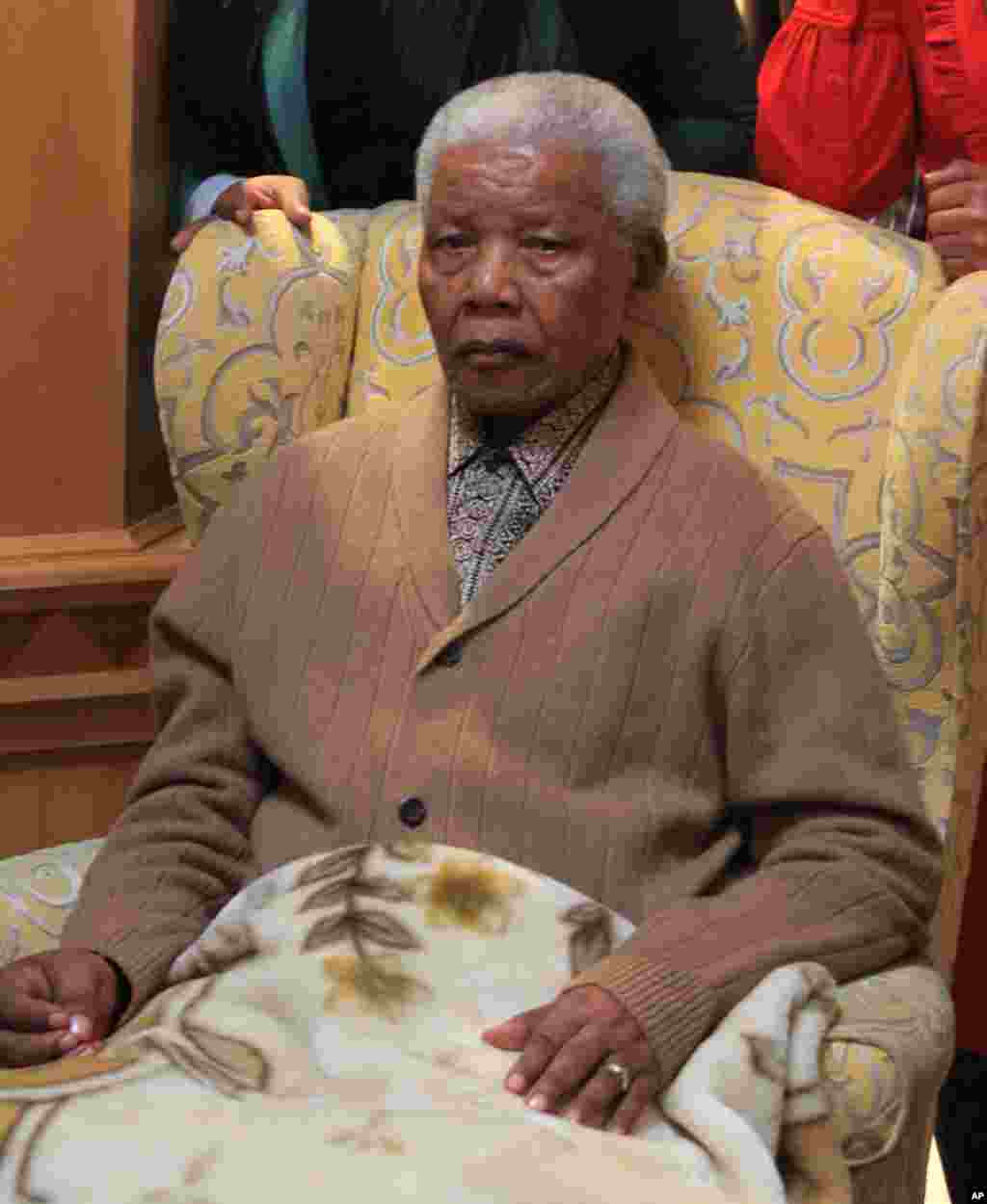 Mandela poses for a photograph after receiving a torch to celebrate the African National Congress' centenary in his home village, Qunu, in rural eastern South Africa, May 30, 2012.