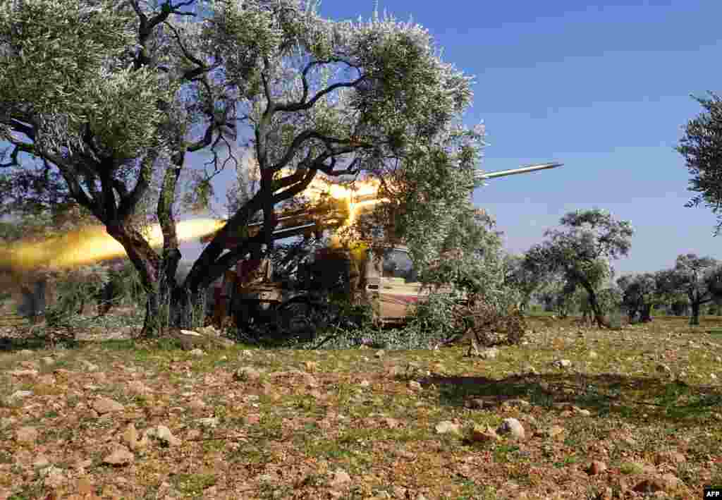 Members of Syria's opposition National Liberation Front remotely-fire a rocket at a position near the village of al-Nayrab, about 14 kilometers southeast of the city of Idlib in northwestern Syria, amid clashes with government forces.