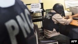 Agentes de la Policía Nacional Civil (PNC) fichan en la Torre de Tribunales a uno de sus cuatro compañeros, entre ellos el jefe de la sección contra el crimen organizado, el 22 de febrero de 2007. 