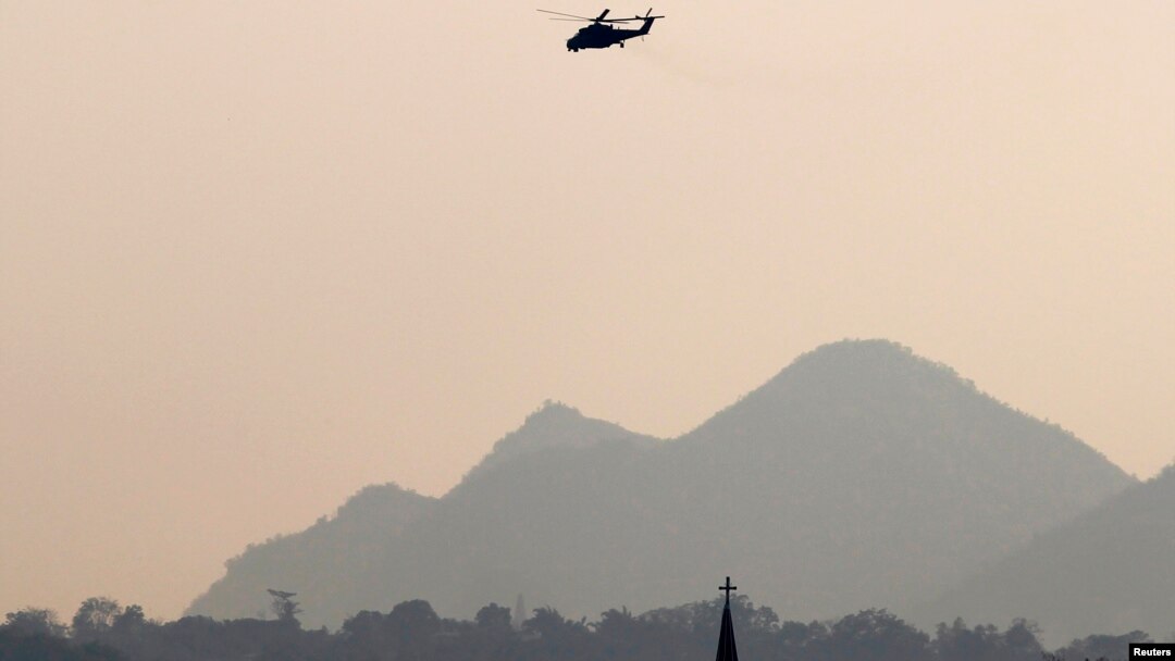 An MI-35M military helicopter flies over Christian church in Lashio, February 19, 2015.
