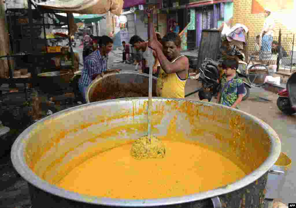 Seorang penjual mempersiapkan 'haleem', makanan khas setempat menjelang berbuka Ramadan di Ahmedabad, India.