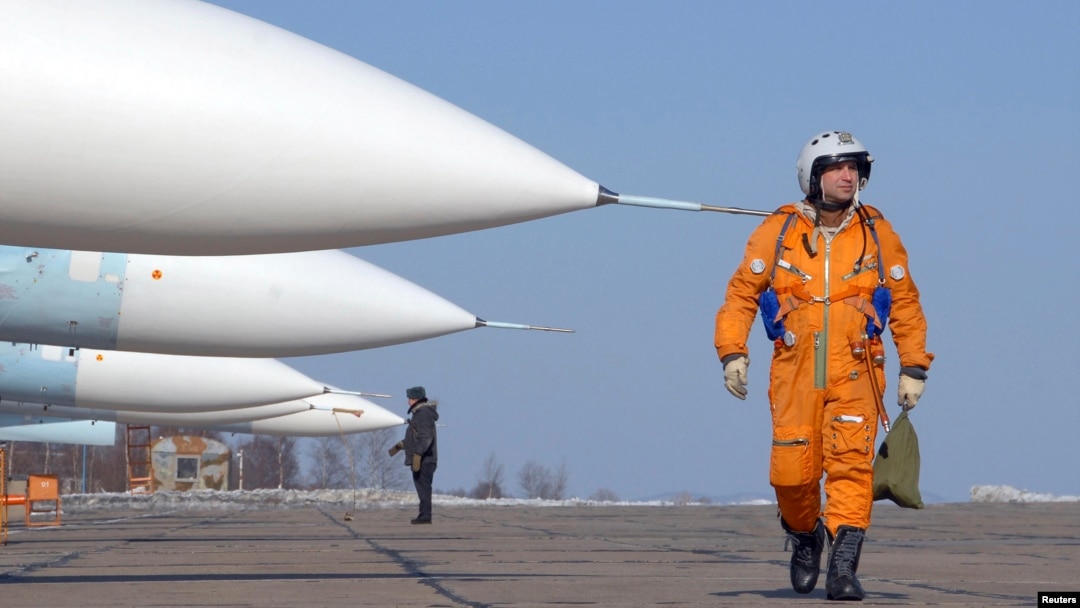 一名飛行員走過在俄羅斯一個空軍基地的停放的蘇-27戰鬥機。