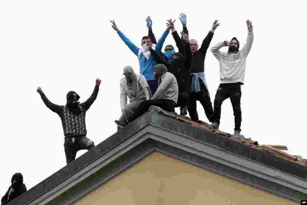 Inmates stage a protest against new rules to cope with coronavirus emergency, including the suspension of relatives' visits, on the roof of the San Vittore prison in Milan, Italy.