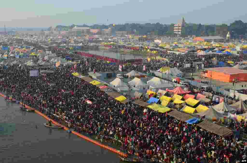 Hindu devotees arrive to take a holy dip at Sangam, the confluence of the rivers Ganges and Yamuna and mythical Saraswati, during the auspicious bathing day of Mauni Amavasya at the annual Magh Mela festival in Allahabad, India.