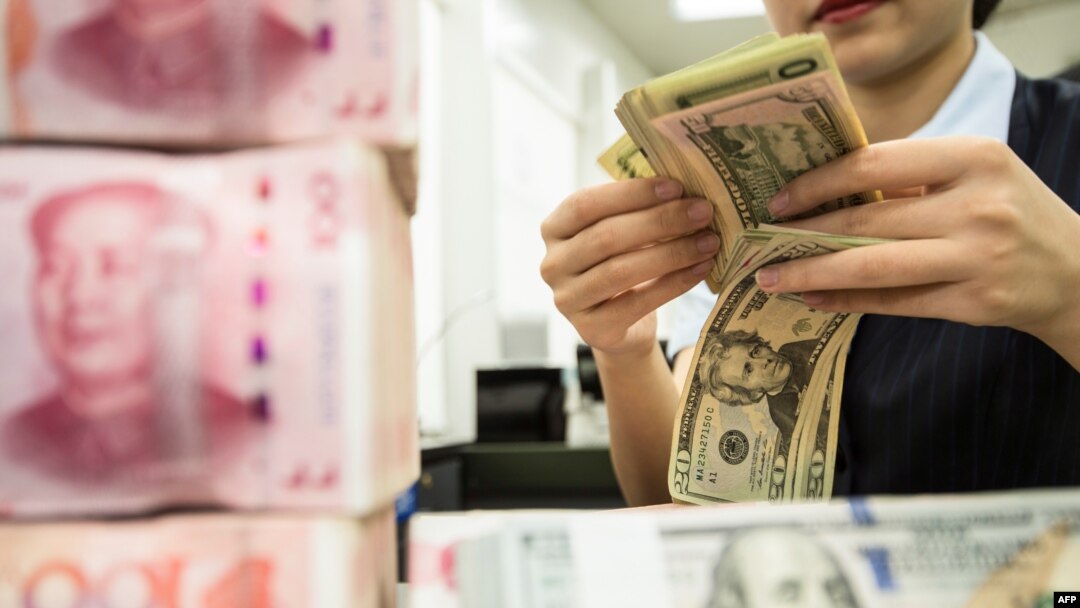中國江蘇南通一家銀行的工作人員正在人民幣旁點數美元。 (2019年8月6日)