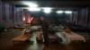 Un hombre espera ser evacuado al oeste de Ucrania, de pie junto a una cama en un teatro de la ciudad que alberga a refugiados que huyen de la ofensiva rusa en la región de Donetsk, en Pavlohrad, región de Dnipropetrovsk, Ucrania, el jueves 12 de diciembre de 2024. 