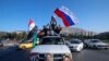 FILE - Syrian government supporters wave Syrian, Iranian and Russian flags during demonstrations following April 2018 military strikes by U.S., British and French forces in Syria. Russia and Iran are allies of Syrian President Bashar al-Assad.