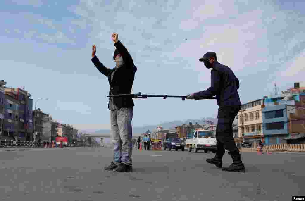 A police officer maintains distance as he detains a man defying the lockdown imposed by the government amid concerns about the spread of coronavirus disease (COVID-19), in Kathmandu, Nepal.