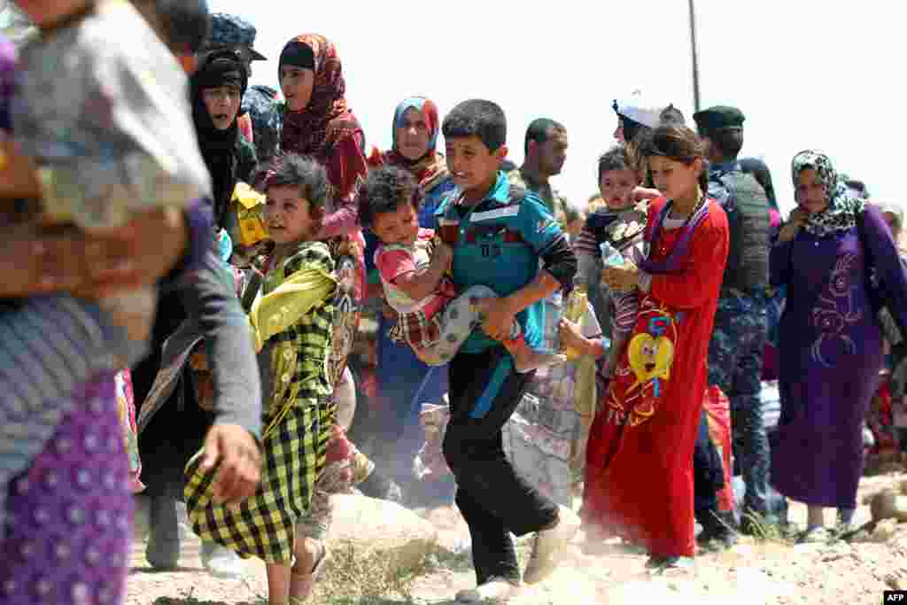 Keluarga-keluarga dekat desa al-Sejar di provinsi Anbar yang melarikan diri dari Fallujah (27/5), di tengah operasi besar untuk merebut kota itu dari tangan Negara Islam (ISIS). (AFP/Ahmad al-Rubaye)