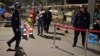 FILE - Residents walk past a security checkpoint at the close of a open-air market in Kashgar in western China's Xinjiang region, Nov. 4, 2017. Authorities are using detentions in political indoctrination centers and surveillance in efforts to control the Xinjiang region and its Uighurs, a Turkic-speaking Muslim minority Beijing fears could be influenced by extremism. 