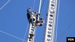 Workers for the country's electricity supplier installing damages electricity poles in Chikwawa district. (Lameck Masina/VOA)