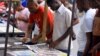 FILE - Civilians read newspapers on display in Dar es Salaam, Tanzania, March 18, 2021. 